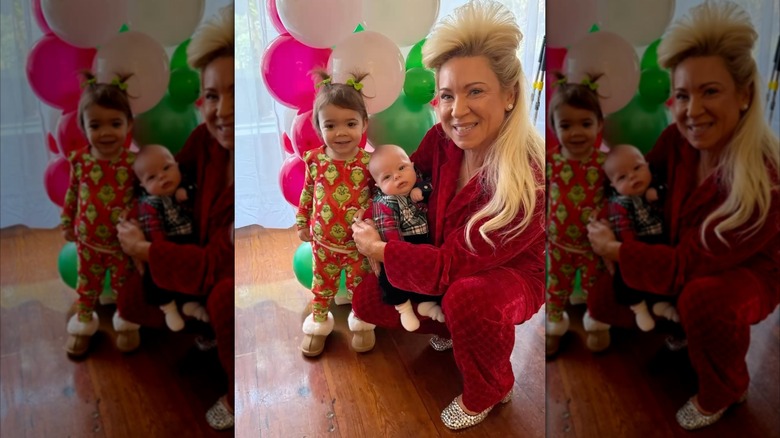Theresa Caputo in Christmas pajamas, squatting down with her two grandkids