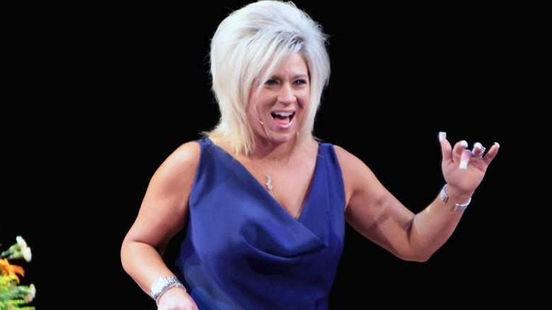 Theresa Caputo onstage wearing a microphone