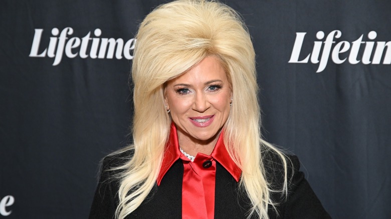 Theresa Caputo, her hair bigger and longer than normal, on a Lifetime step-and-repeat