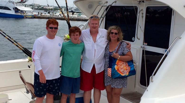 Maggie Murdaugh in blue and sunglasses with husband and sons on a boat