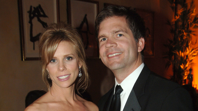 Cheryl Hines and Paul Young smiling while posing at an event together