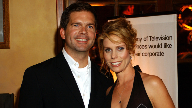 Cheryl Hines and Paul Young smiling while posing at an event together