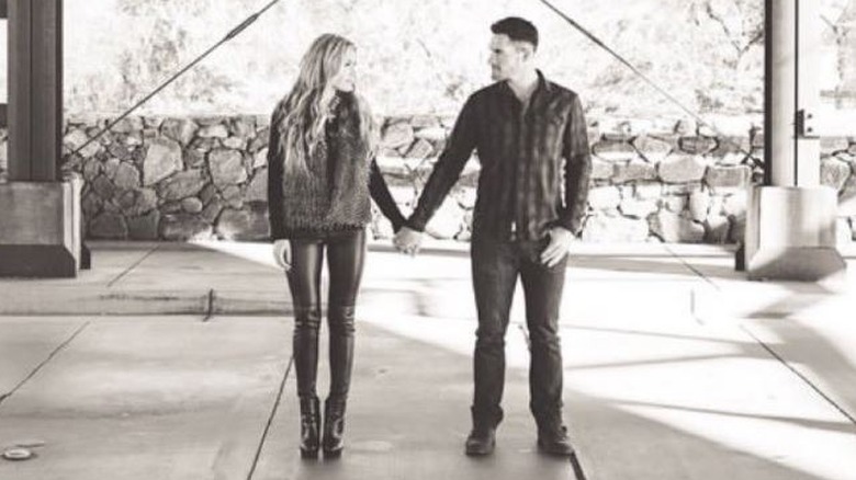 Erika Kirk holding hands with JT Massey in a black and white engagement style picture.