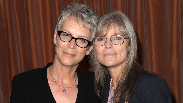 Sisters Jamie Lee and Kelly Curtis pose side by side in 2012 smiling contently at the camera