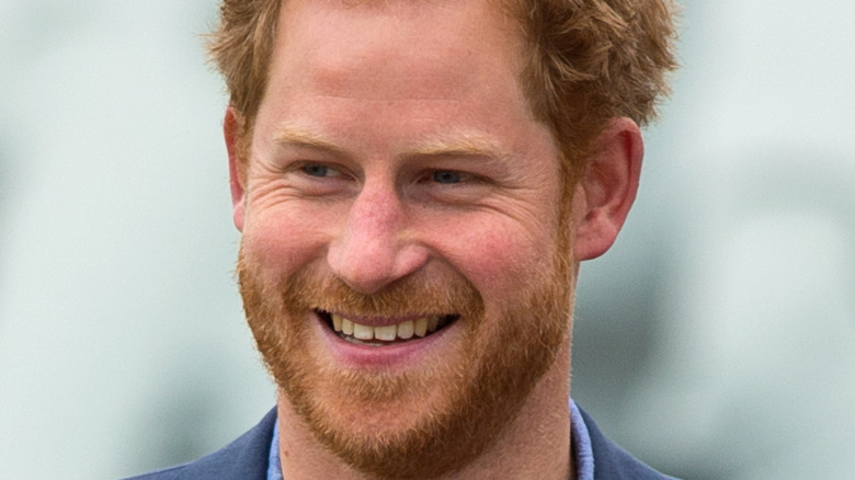 Prince Harry smiling in a blue suit