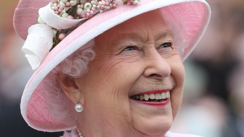Queen Elizabeth smiling widely in pink