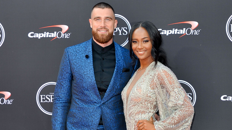 Travis Kelce and Kayla Nicole smiling while posing at an event together