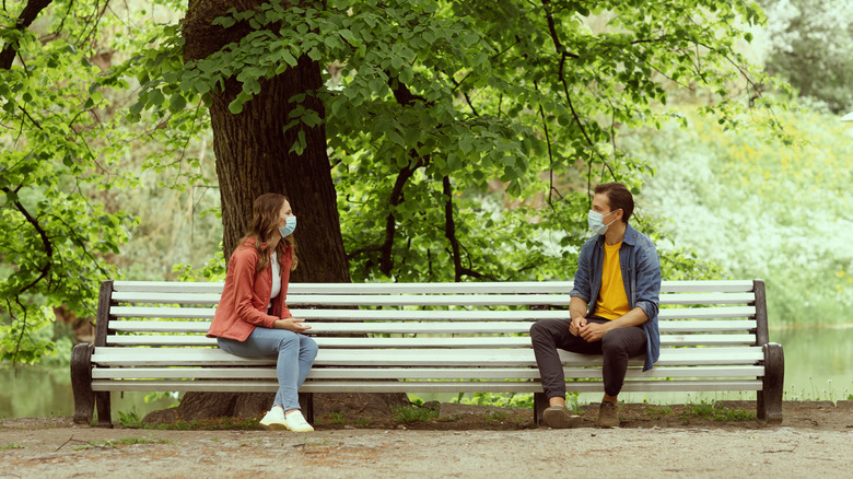 Masked couple on a park bench