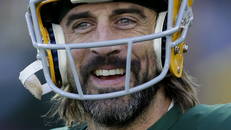 Aaron Rodgers smiles through his football helmet