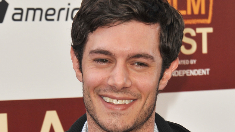 Adam Brody smiles at an event