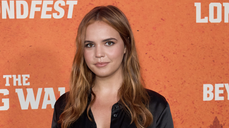 Bailee Madison in front of orange backdrop