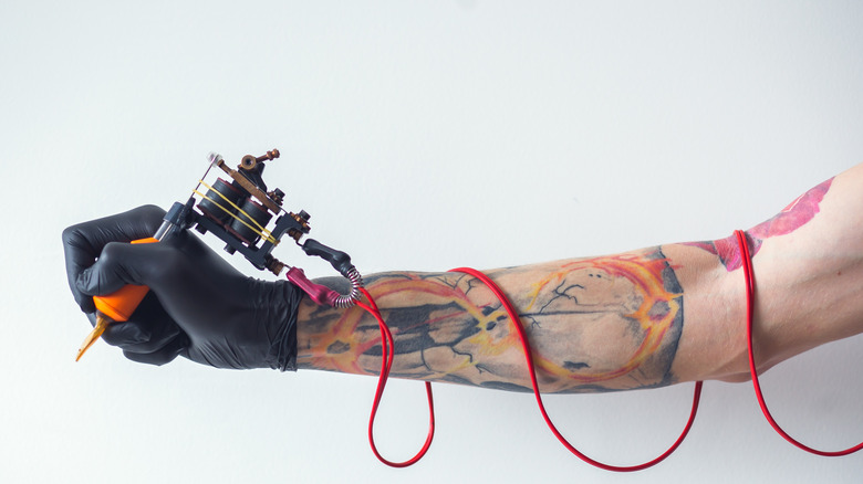 Person holding tattoo machine 