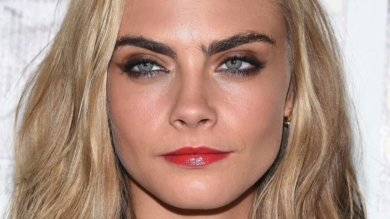 Cara Delevingne red lipstick dark eyebrows blond