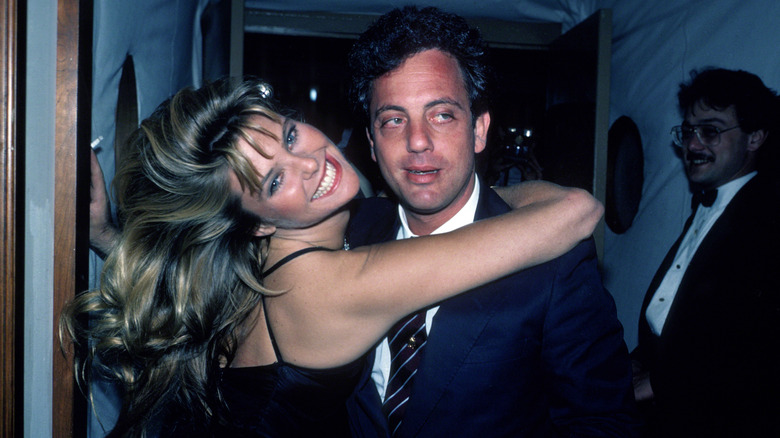 Christie Brinkley smiling with her arms around Billy Joel