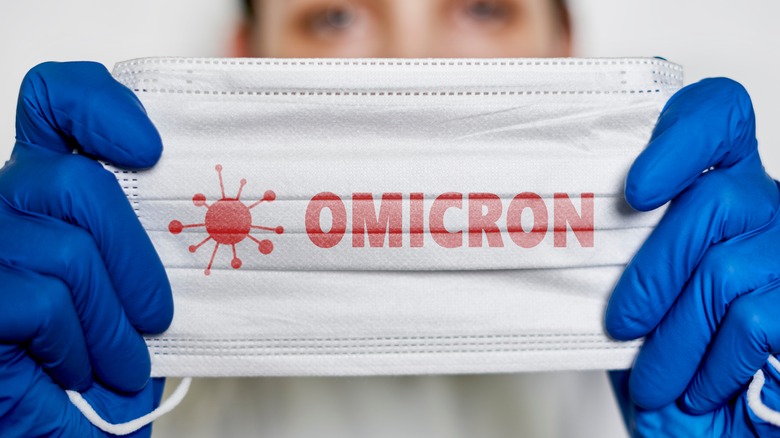 Physician holding a mask that says Omicron