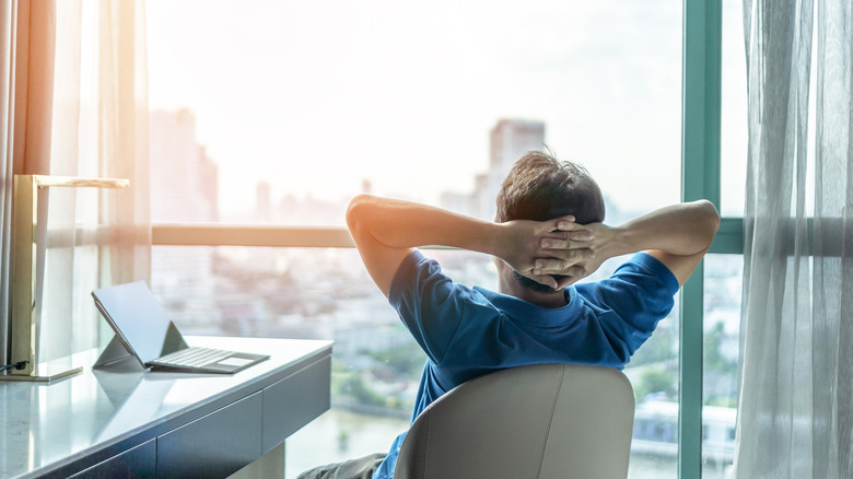 Relaxed man looking out city window