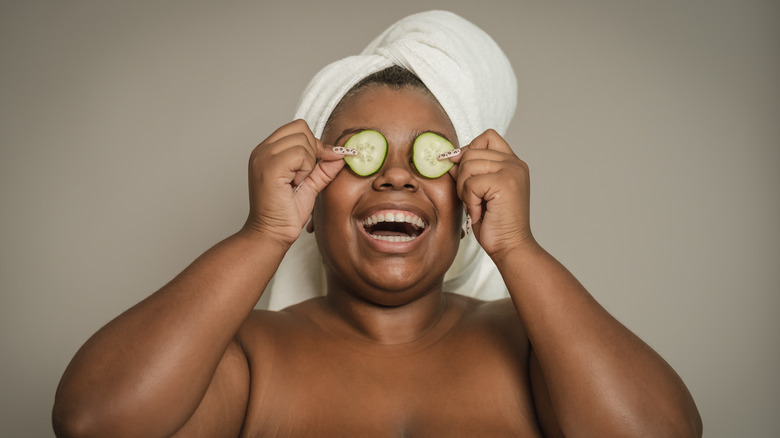 Woman with cucumber on eyes