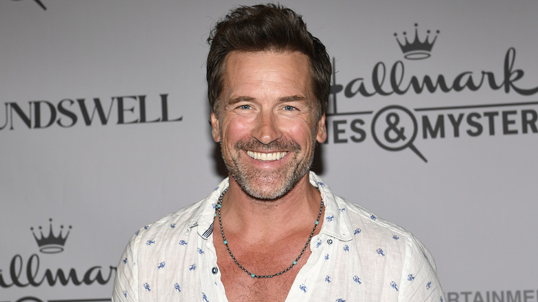 Paul Greene smiling in a white patterned shirt while posing at a Hallmark event