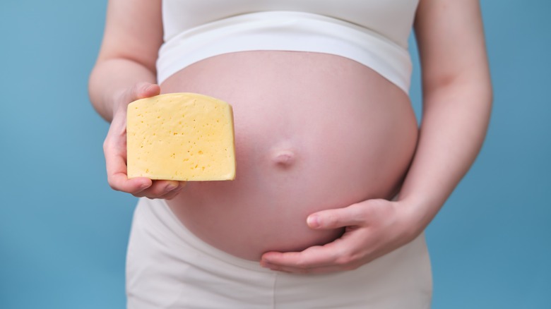 pregnant woman holding cheese