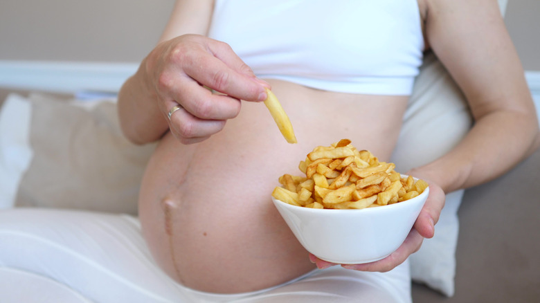 Pregnant woman eating fries