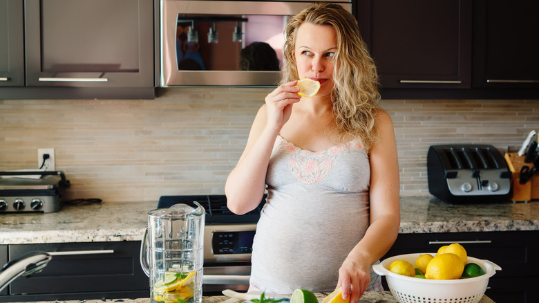 pregnant woman eating lemons