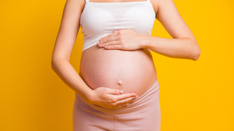 Pregnant woman holding belly