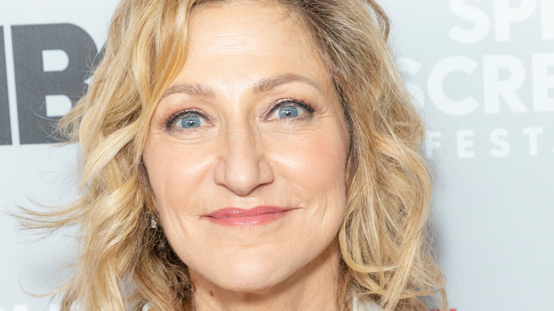 Edie Falco grinning with hair down