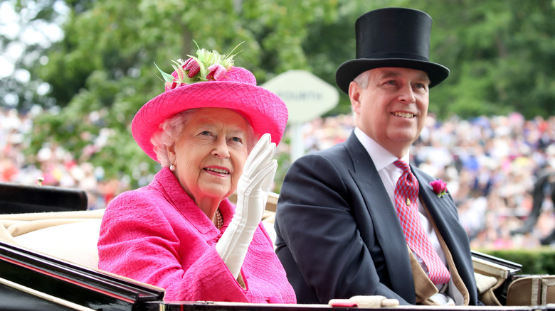 Queen Elizabeth in pink waving with Prince Andrew in open carriage