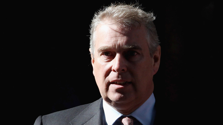 Prince Andrew standing with somber expression