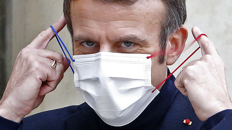 Emmanuel Macron putting on a face mask