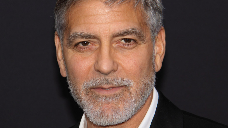 George Clooney smiles with a gray beard.