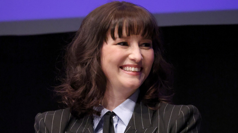 Chyler Leigh smiling onstage in a pinstriped suit