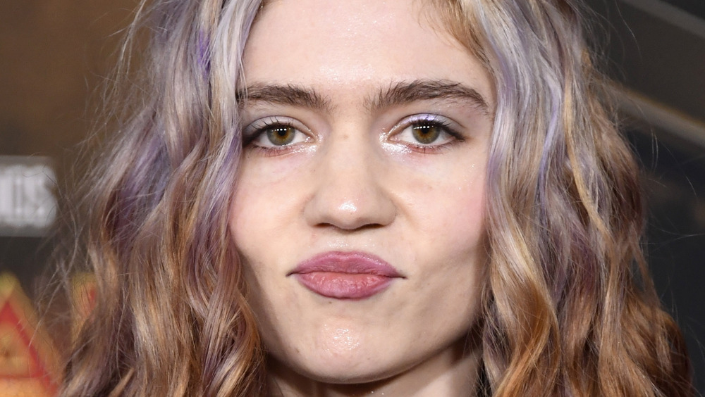 The singer Grimes with pursed lips