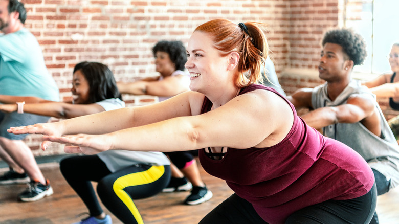 People doing squats in group fitness class