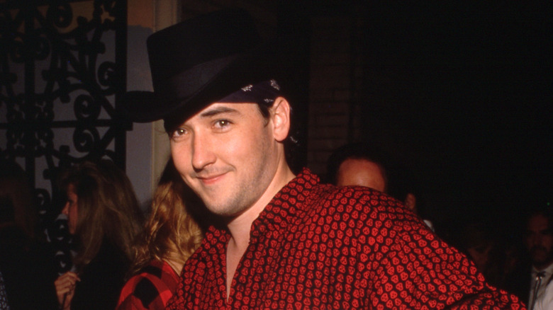 John Cusack smiling in the 1980s.