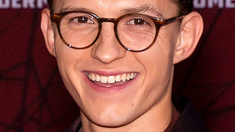 Tom Holland with wide smile and glasses