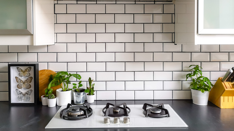 Subway tile with black grout behind stove top