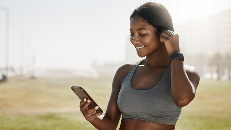 A woman in a sports bra listening to music.