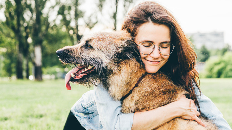 Woman hugging her dog outdoors