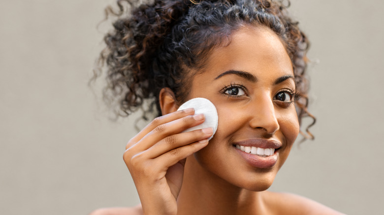 woman wiping face with cotton