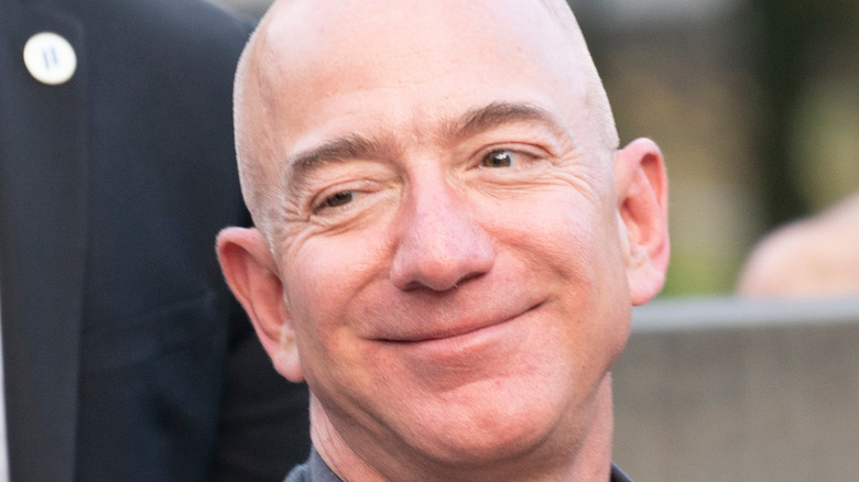 Jeff Bezos smiling in a gray suit