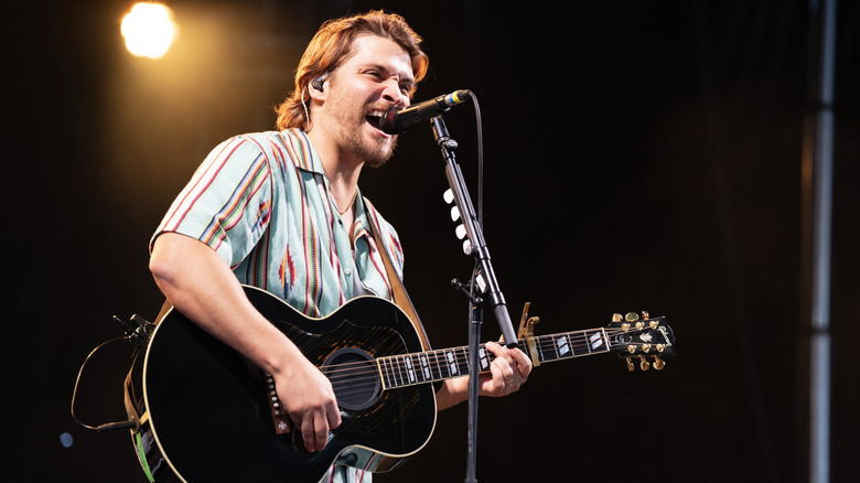 Luke Grimes playing guitar and singing