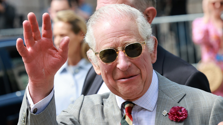 King Charles waving in sunglasses