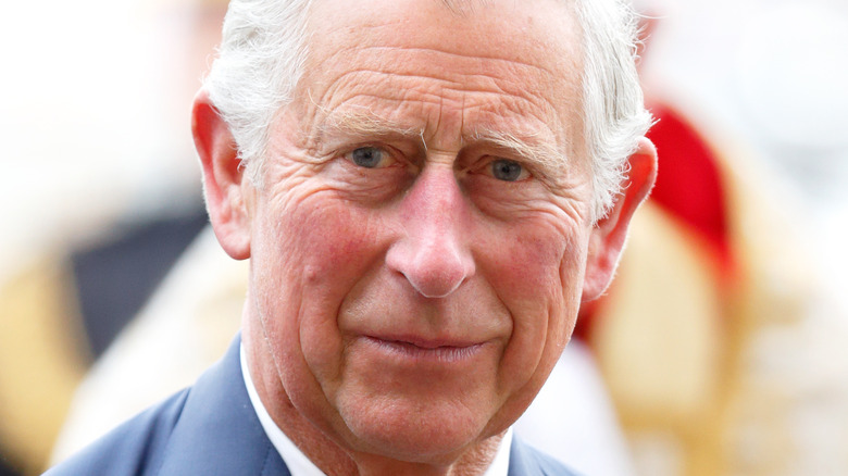 King Charles III smiling in a suit