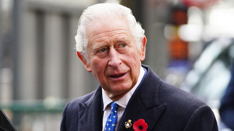 King Charles III walking into a building