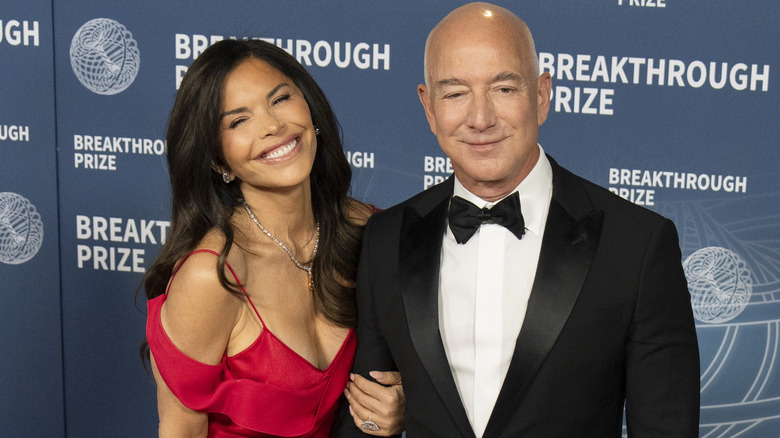 Lauren Sánchez smiling while holding Jeff Bezos' arm