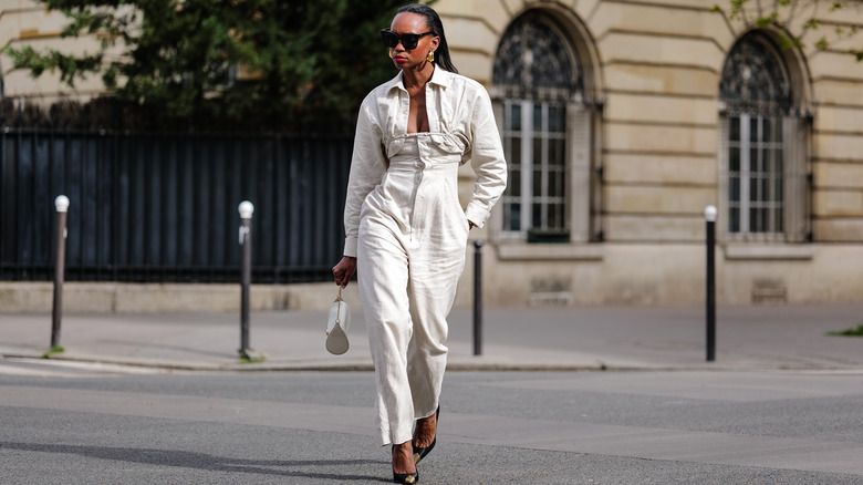 woman wearing cream linen jumpsuit, black heels