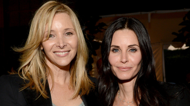 Lisa Kudrow and Courteney Cox  smiling while posing at an event together