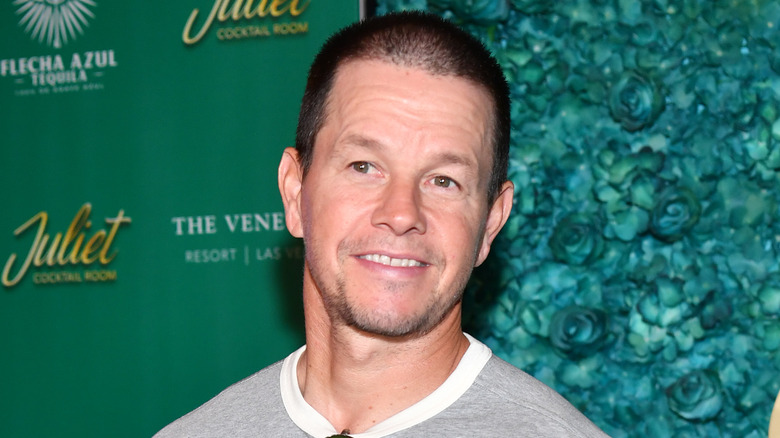Mark Wahlberg smiling green background