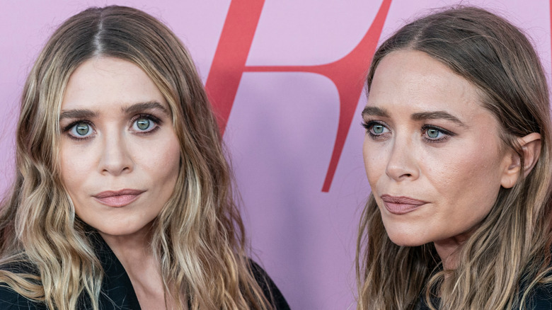 Mary Kate and Ashley Olsen posing